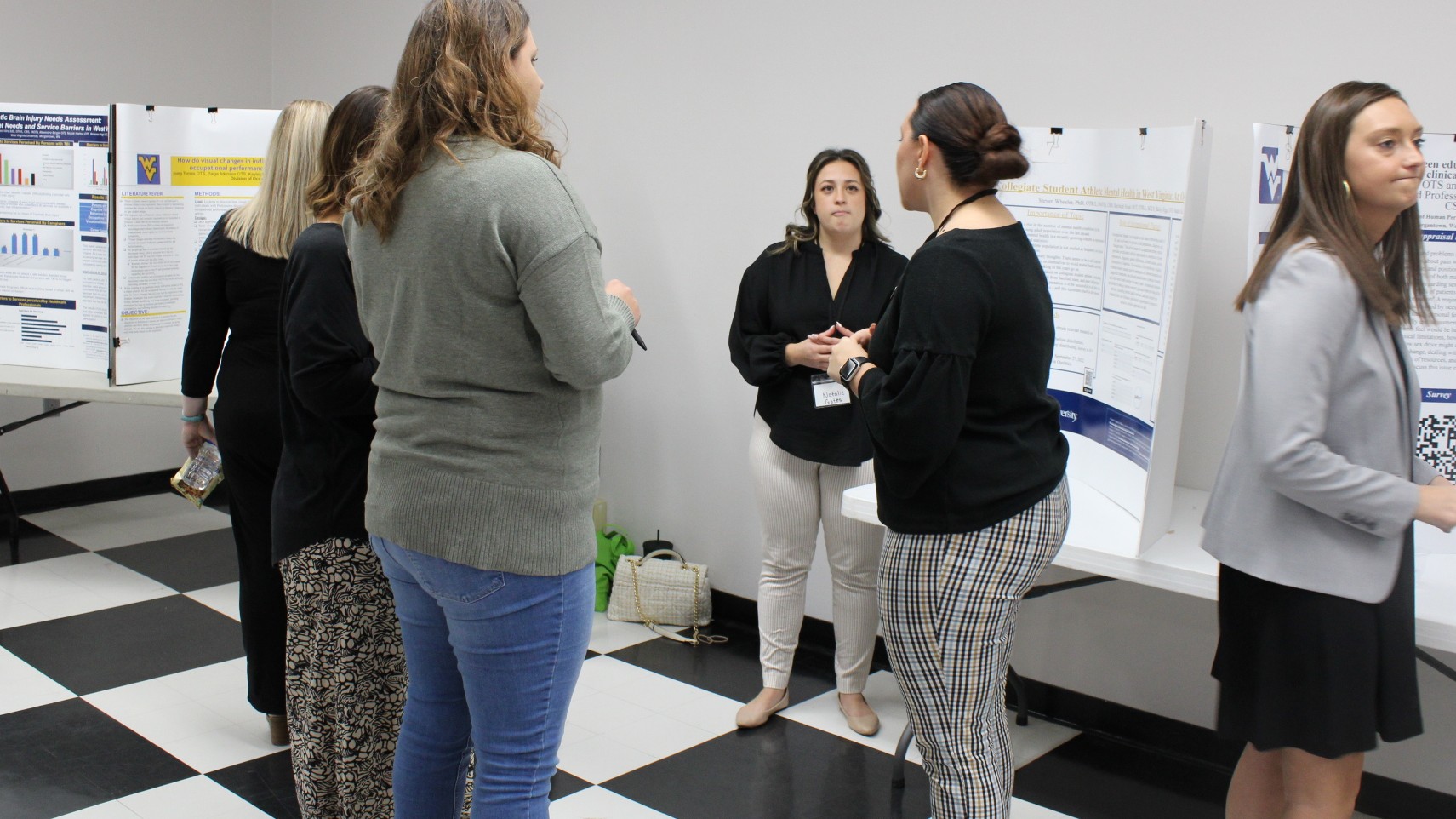 OTS gathered around a research poster in discussions